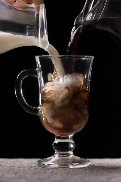 istock Pouring coffee and milk into a glass with ice 1303464821