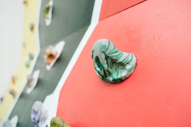 Green hand grip of a wooden climb wall.