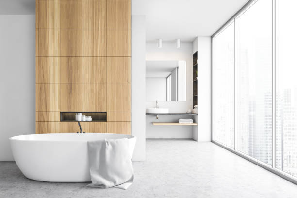 istock Bathtub in open space bathroom, sink and mirror on background with window 1303469380