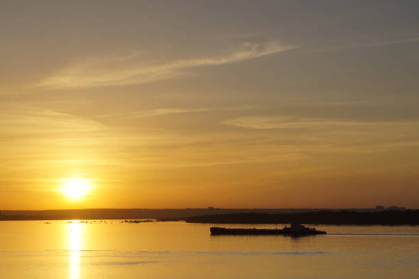 Little fishing boat accross the lake at the sunset