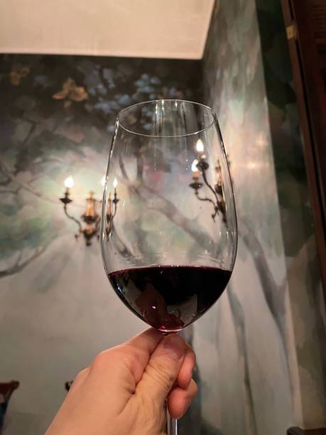 istock a glass of red wine in hand 1303470840