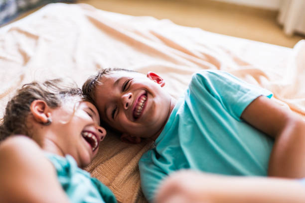 istock Beautiful children playing on the bed 1303472499