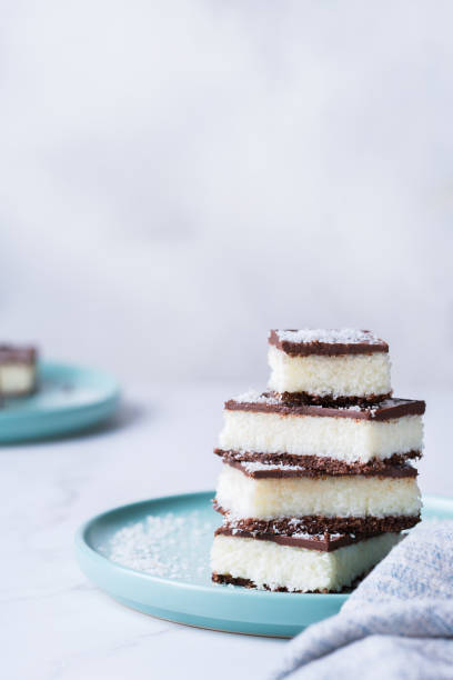 istock Organic raw vegan coconut bars with chocolate on kitchen table 1303474456