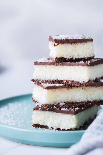 istock Organic raw vegan coconut bars with chocolate on kitchen table 1303474475