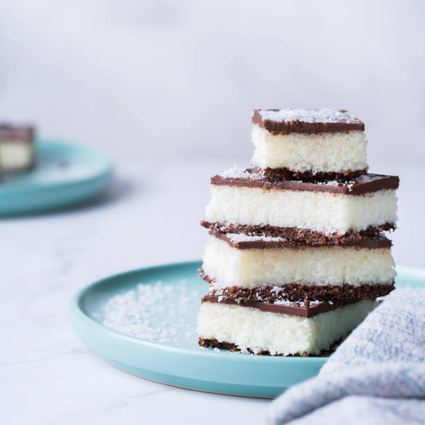 istock Organic raw vegan coconut bars with chocolate on kitchen table 1303474485