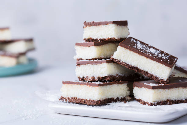 istock Organic raw vegan coconut bars with chocolate on kitchen table 1303474507