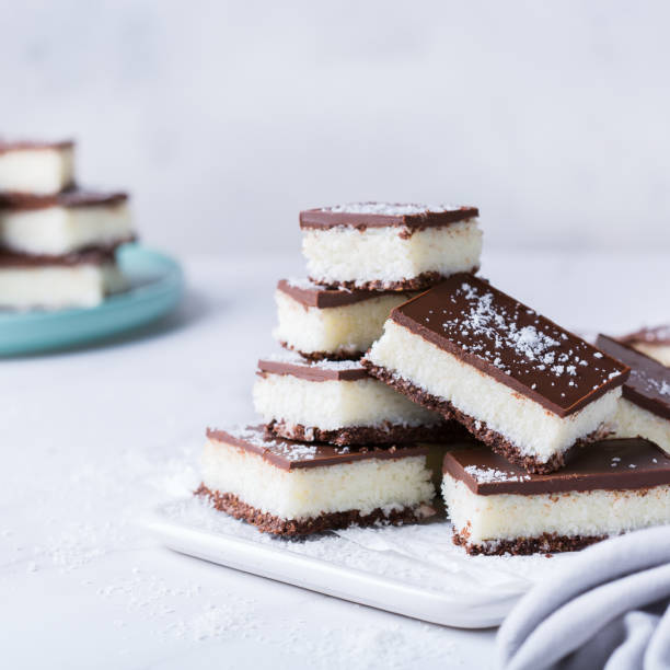istock Organic raw vegan coconut bars with chocolate on kitchen table 1303474551