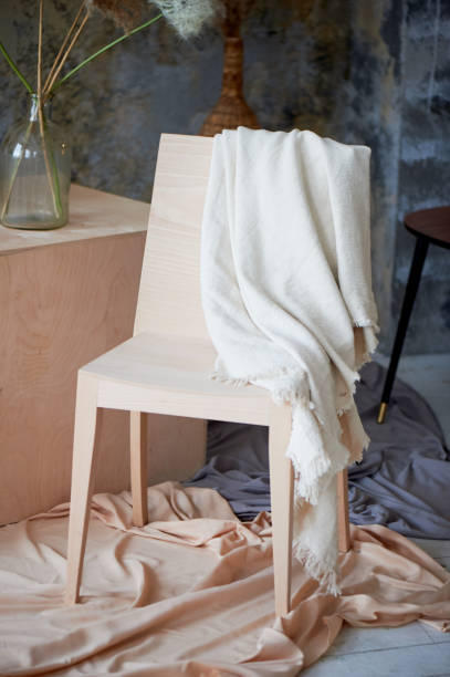 istock Light interior with wooden chair, cubes and draped fabric. A creative workshop 1303475329