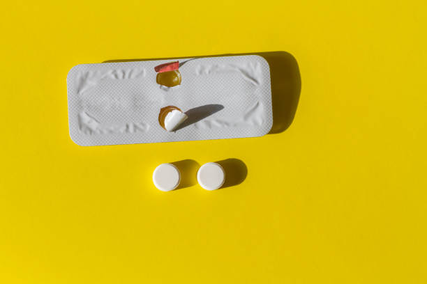 Two pills for emergency contraception and a blister on a yellow background stock photo