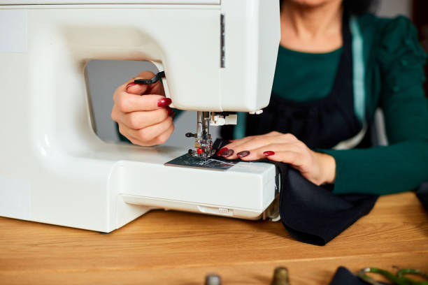istock Step by step, 50-yers old woman sews clothes on sewing machine 1303476653
