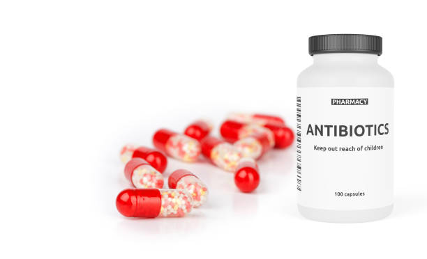 garrafa de farmácia com pílulas vermelhas isoladas em um branco - antibiotic - fotografias e filmes do acervo