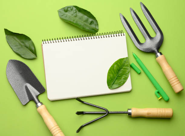 istock open notebook with blank white sheets and various gardening tools with wooden handles 1303480935