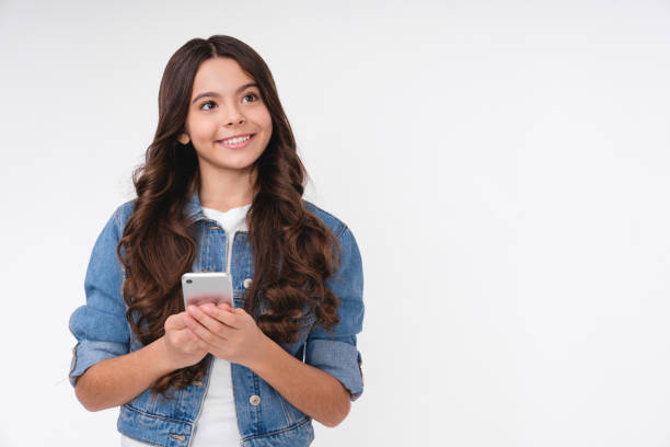 白い背景に隔離されたスマートフォンを使用して夢のような白人の十代の少女 - teenager adolescence portrait pensive ストックフォトと画像