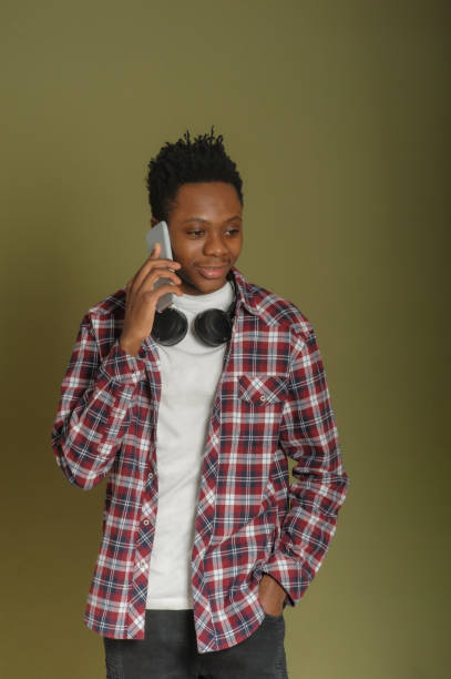 istock young african american guy talking on the phone on a green background 1303482956