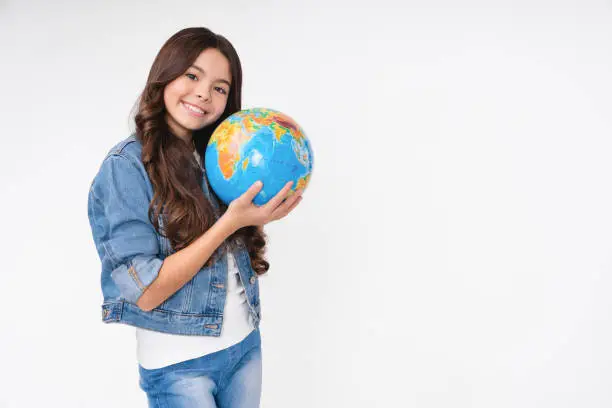 Photo of Smiling happy teen girl holding globe with care and love isolated in white background