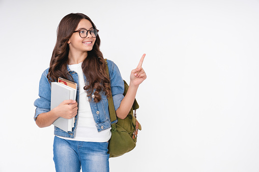 Teenage school girl with backpack isolated in white background