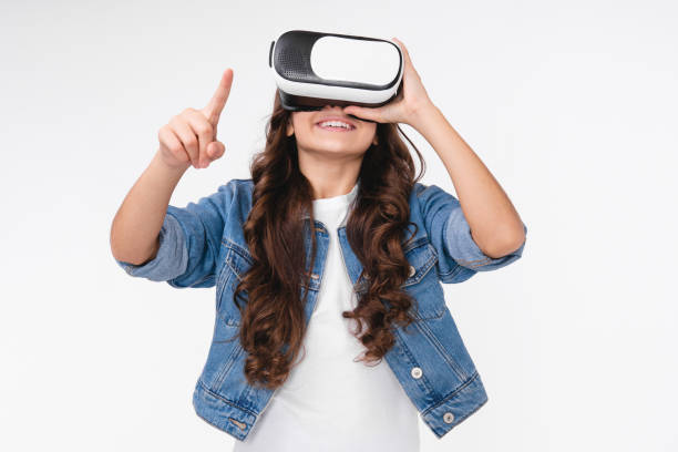 istock Beautiful young white girl using VR glasses and pointing at copy space isolated over white background 1303483770