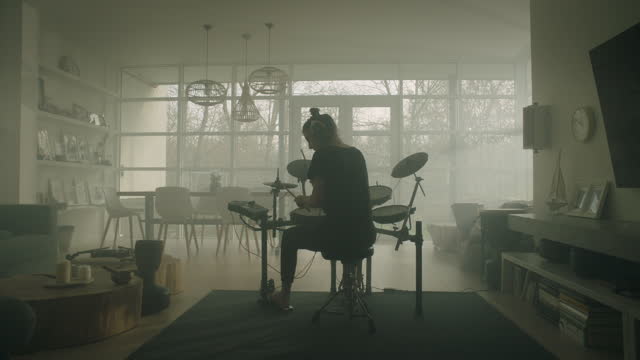 Young woman practicing on electronic drums in his living room