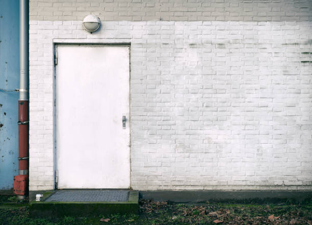 White gray painted brick wall with white steel door.