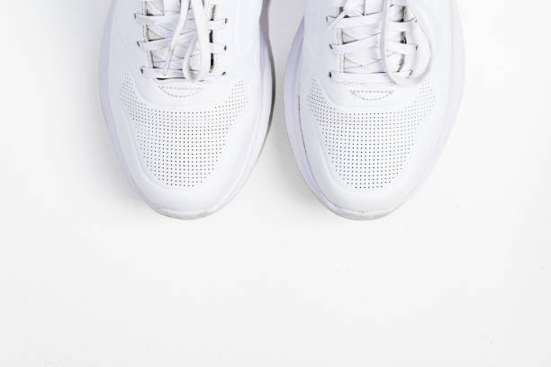 istock Pair of stylish sneakers on white background, top view 1303486116