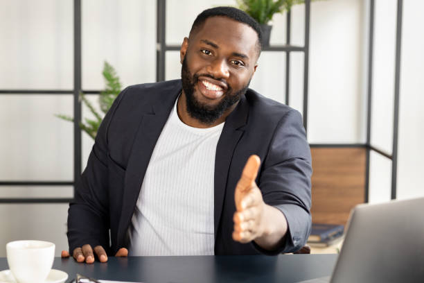 istock African american man smiling extending hand at camera handshake concept greeting 1303487377