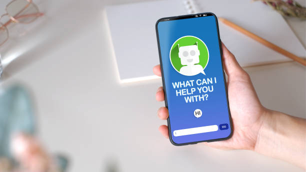 close up hand chat with chatbot on mobile app.top view holding mobile over table at home.artificial intelligence technology in human lifestyle
