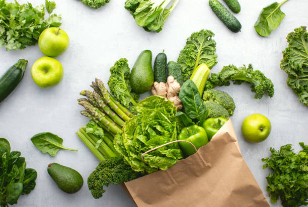 Green vegetables in a paper shopping bag, top down view