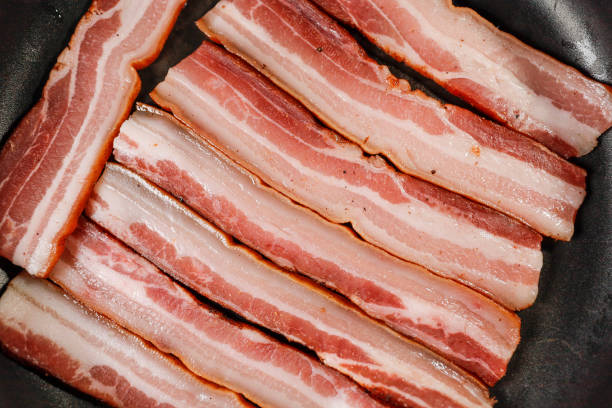 istock Italian pancetta frying in a pan 1303489797