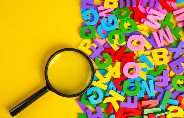 istock Magnifying glass with colorful alphabet on yellow background.Education concept. 1303492128