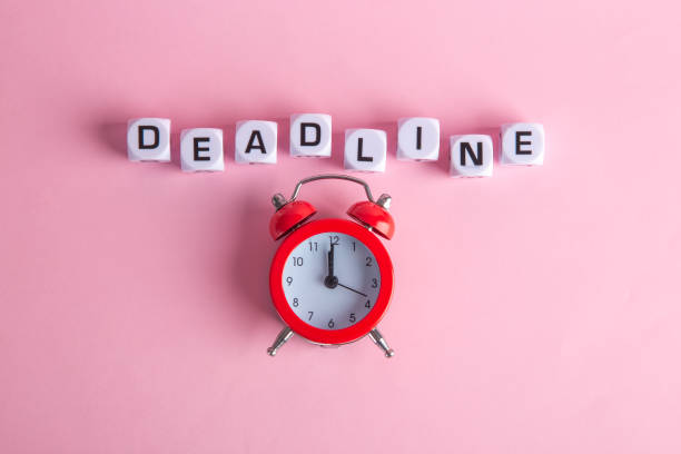 istock Letters with a red clock on a pink background. Concept dead line. Top view. 1303492794