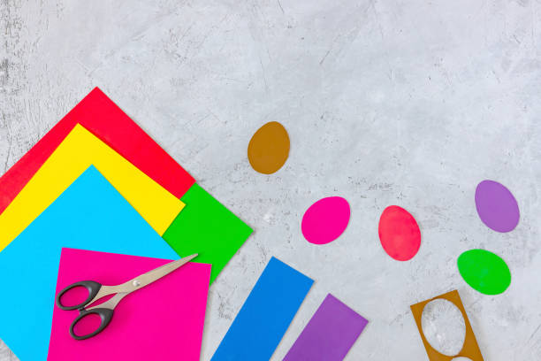 istock scissors, colored paper, and cut-out eggs on a concrete background 1303494306