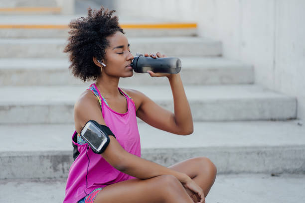 istock Athletic woman drinking water after work out outdoors. 1303497741