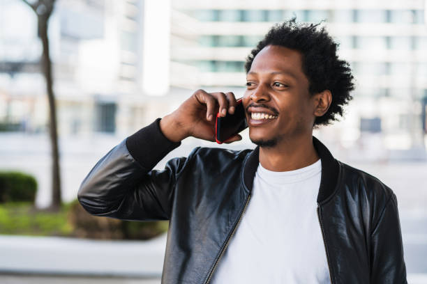 istock Afro man talking on the phone outdoors. 1303497745