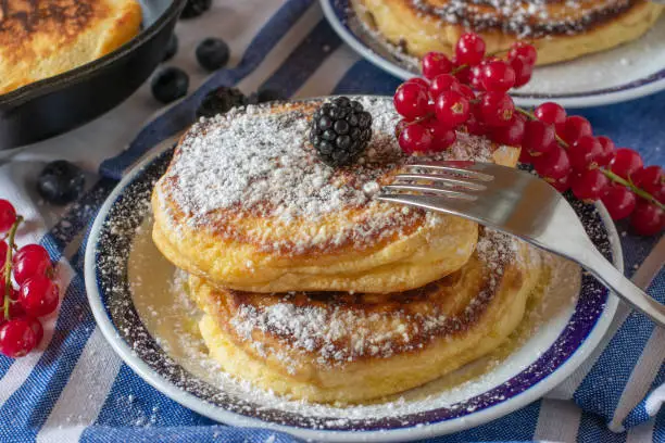 fresh dutch pancakes with powdered sugar and melted butter on a plate. Ready to eat