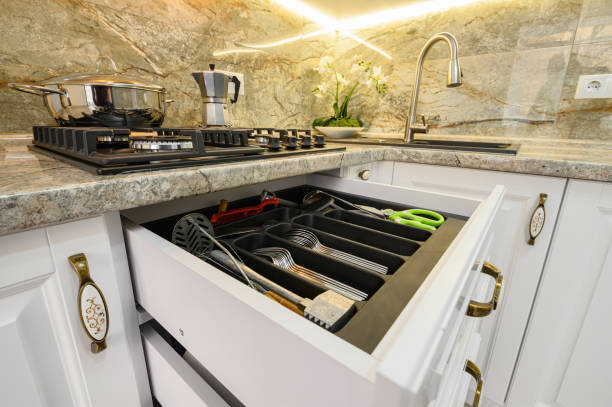 istock Drawers pulled out at modern classic white kitchen furniture 1303498125