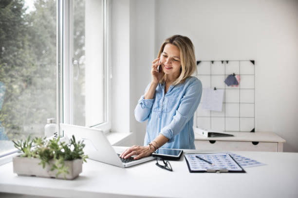 istock Businesswoman working at ergonomic standing workstation. 1303500438