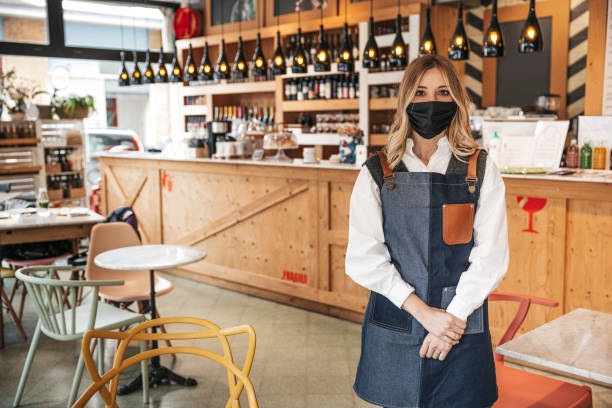 istock Waiter with a surgical mask posing in his bar 1303501164