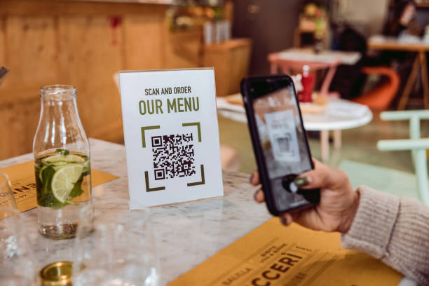 mujer consultando el menú del restaurante con código qr - menú fotografías e imágenes de stock