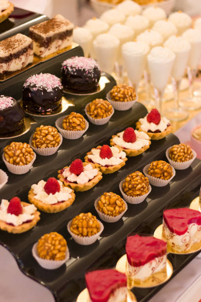 istock Single serving desserts on a modern stand of a buffet table, wedding candy bar 1303502064