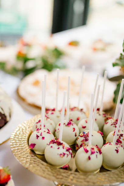 istock White cake pops on a golden plate, Wedding candy bar 1303502457