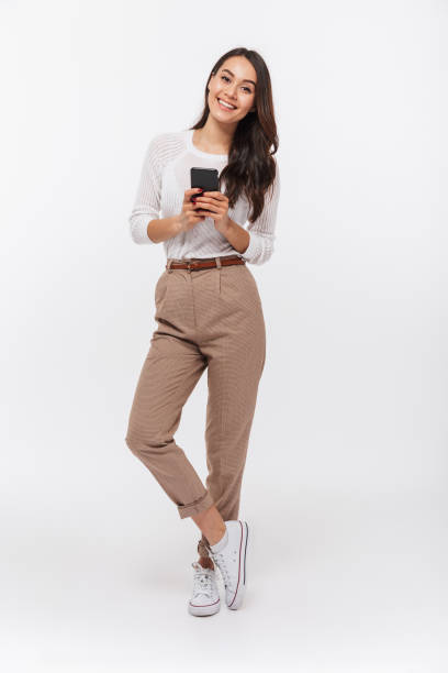 verticale pleine longueur d’une femme d’affaires asiatique heureuse - technology mobile phone clothing smiling photos et images de collection
