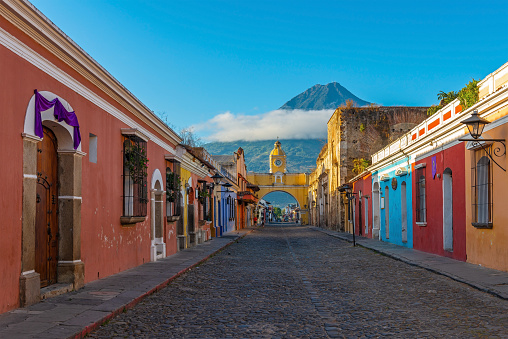 Cityscape of a street in Antigua with Santa Catalina Arch and Agua volcano, Guatemala.