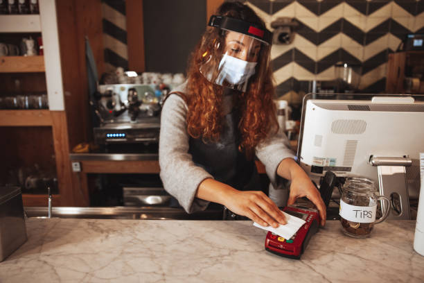 istock Restaurant Wait staff cleaning POS with a wet wipe 1303503967