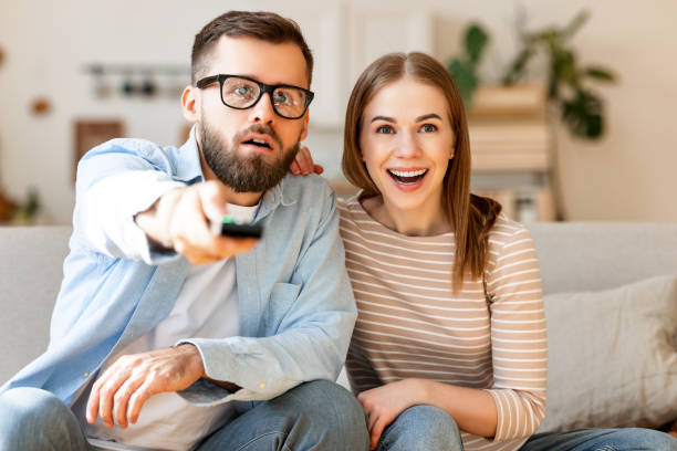 istock Amazed couple watching TV together 1303505213