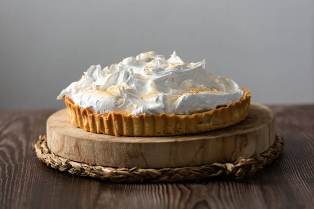 istock Lemon pie on top of log and wooden table. front view 1303505289