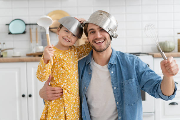 istock Caucasian father and daughter enjoy battle funny activity in kitchen spend active time together on weekend at home 1303505459