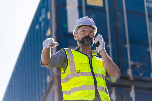 istock Logistics engineer stand on and Pointing up around Shipping container stacker in commercial transport port 1303505568