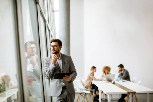 istock Young modern businessman using digital tablet in the office 1303505948