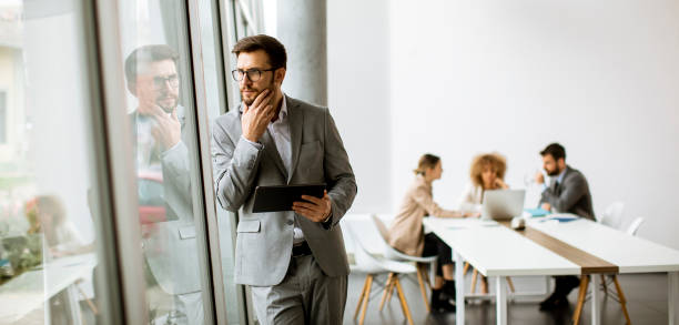 istock Young modern businessman using digital tablet in the office 1303505951