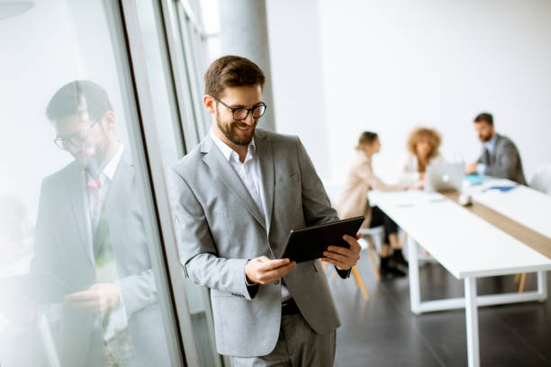 istock Young modern businessman using  digital tablet in the office 1303505955